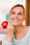 Beautiful Relaxed Woman Holding an Apple Beside Her Face