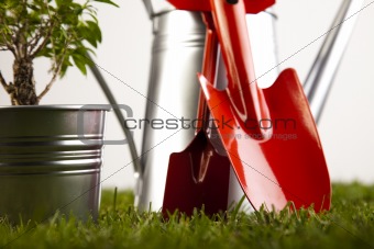 Gardening equipment on green grass with plants