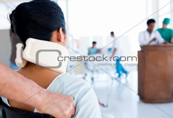 Brunette woman with a neckbrace sitting on wheelchair