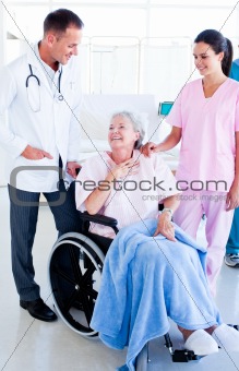 Smiling medical team taking care of a senior woman