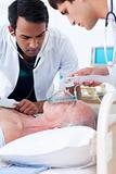 Multi-ethnic Doctors resuscitating a senior patient 