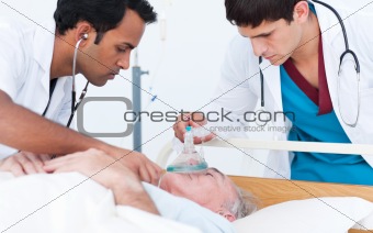Young doctor putting oxygen mask on a senior patient 