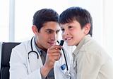 Serious doctor examining little boy's ears
