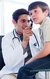 Charismatic doctor examining little boy's ears