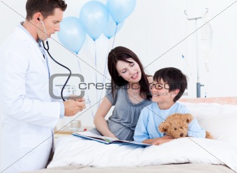 Attentive doctor talking with a little boy and his mother