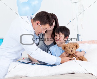 Attentive doctor playing with a little boy and his mother