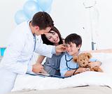 Charming doctor playing with a little boy and his mother