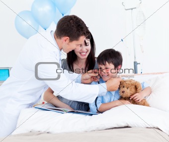 Smiling doctor playing with a little boy and his mother