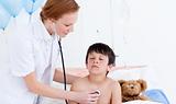 Pretty doctor examining a little boy