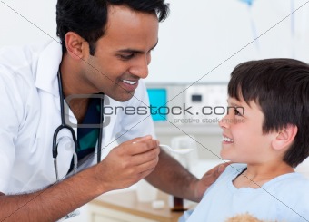 Handsome doctor giving medicine to a little boy