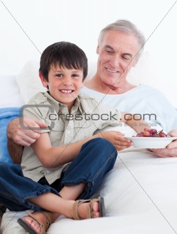 Affectionate little boy taking care of his grandfather