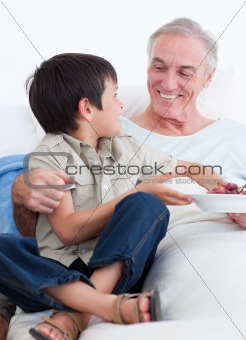 Adorable little boy taking care of his grandfather