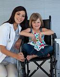Cute girl sitting on a wheelchair with a female doctor