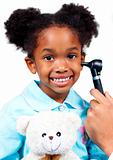 Smiling little girl attending medical check-up holding a teddy b