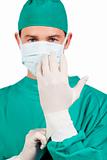Serious surgeon wearing surgical gloves 