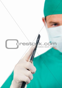 Assertive male surgeon holding a scalpel 