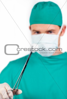 Charismatic male surgeon holding surgical forceps