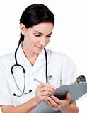 Confident female doctor writing on a clipboard 