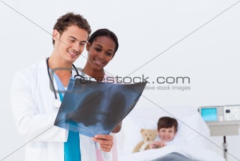 Doctor and nurse examining an x-ray in a bedroom's kid