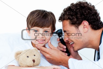 Smiling doctor examining patient's ears
