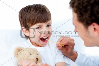 Young doctor taking little boy's temperature