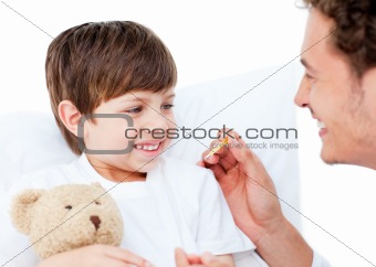 Enthusiastic doctor taking little boy\'s temperature