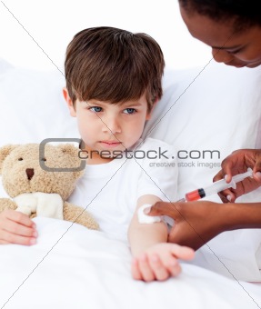 Sick little boy receiving an injection 