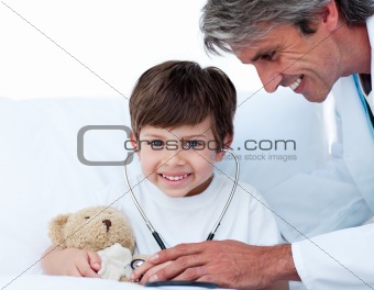 Attentive doctor playing with a little boy 