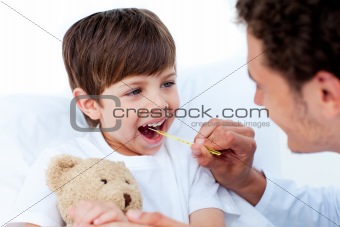 Male doctor taking little boy's temperature 