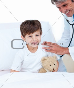 Portrait of a serious doctor examining a little boy at the hospital