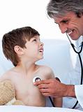 Mature male doctor checking little boy's pulse 