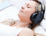Attractive woman with headphones on sleeping on a bed