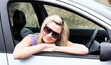 Beautiful young female driver wearing sunglasses