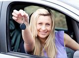 Enthusiastic young driver holding a key after bying a new car 
