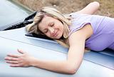Cheerful female driver huging her new car 