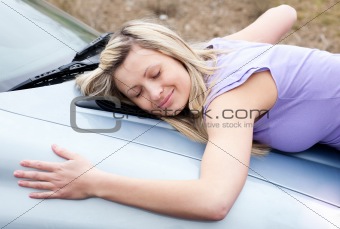 Cheerful female driver huging her new car 