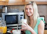Smiling woman having an healthy breakfast in a kitchen