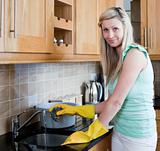 Smiling young woman cleaning in a kitchen