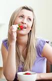 Portrait of a beautiful woman eating a strawberry