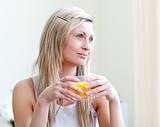 Portrait of a relaxed young woman drinking an orange juice