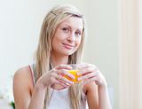 Portrait of an attractive woman drinking an orange juice
