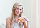 Portrait of a cheerful woman drinking an orange juice