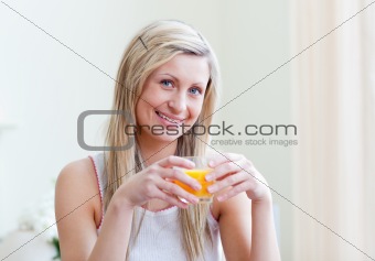 Portrait of a cheerful woman drinking an orange juice