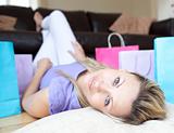 Tired charming woman after shopping lying on the floor