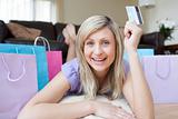 Enthusiastic woman holding a credit card after shopping