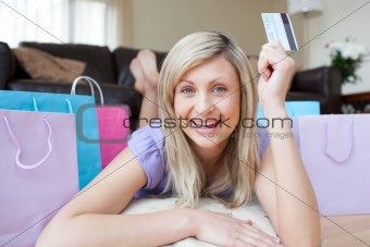 Enthusiastic woman holding a credit card after shopping