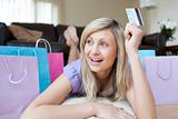 Joyful woman holding a credit card after shopping 