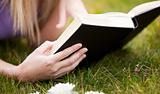 Close-up of a woman reading a book in a park 