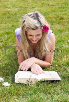 Young woman reading a book in a park 