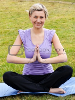 Happy woman doing yoga in a park